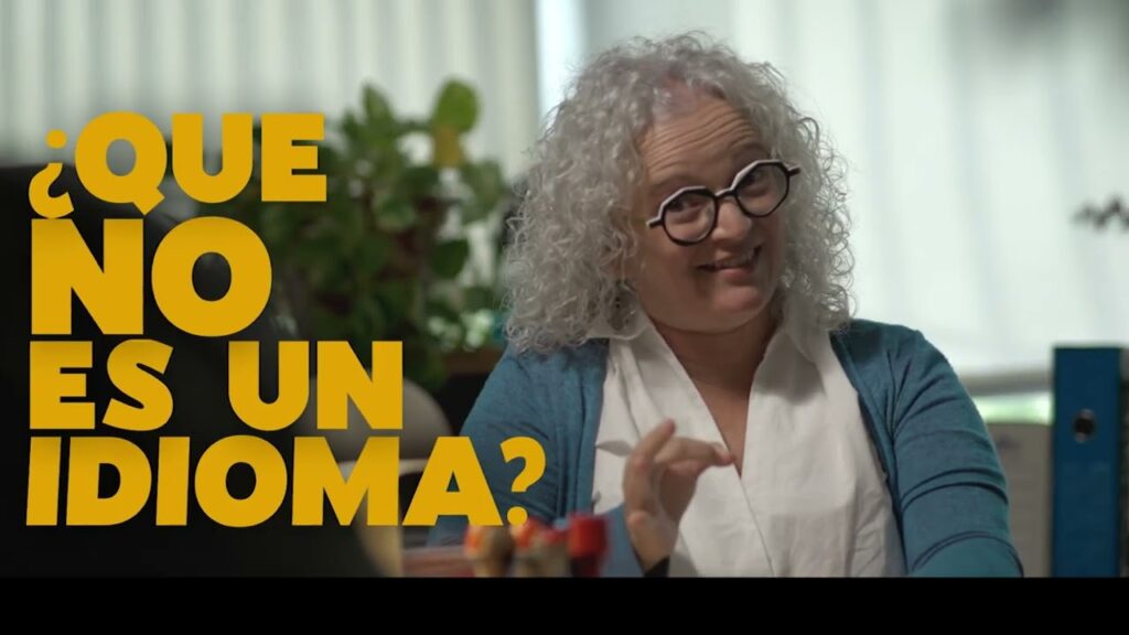 Mujer signando junto con el texto ¿Que no es un idioma?