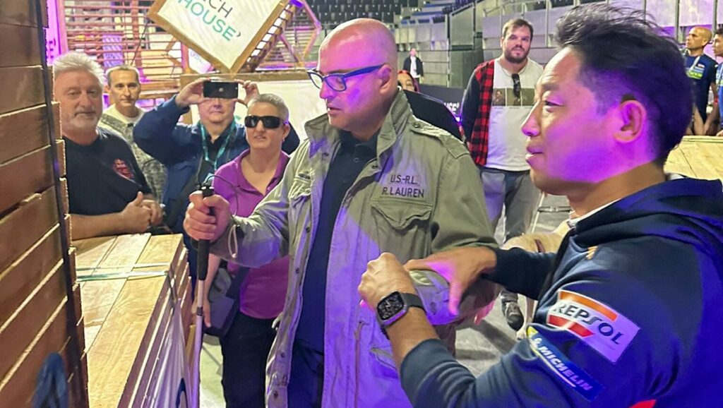 Asistente ciego explora táctilmente uno de los obstáculos de la prueba con la ayuda de uno de los pilotos.