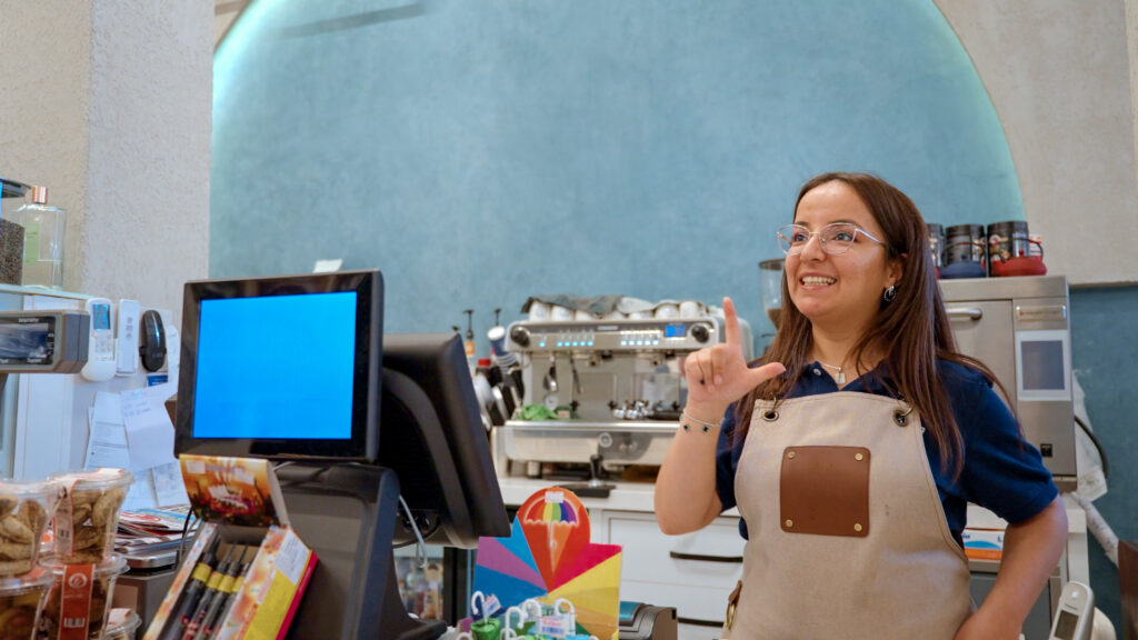 Empleada de cafetería comunicándose en lengua de signos