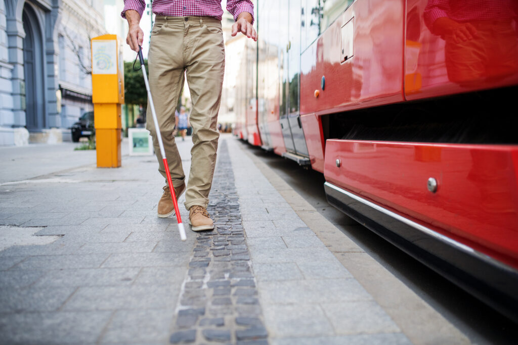 Blind man on a train platform following the tactile pavement indicator.